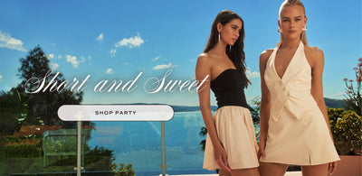 2 girls standing outdoors with the ocean view in the background. Short and Sweet. Shop party.