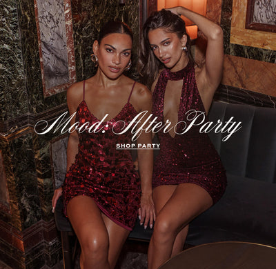 2 Girls sitting in a bar wearing red sequin dresses. Mood: After Party. Shop Party.